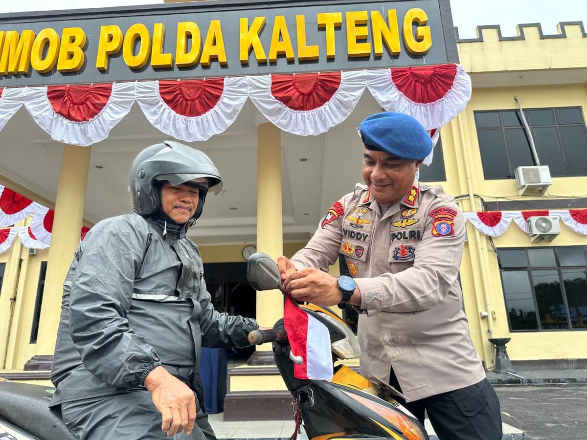 Jelang 17 Agustus, Brimob Kalteng Gelorakan Patriotisme Lewat Pembagian Bendera ke Warga