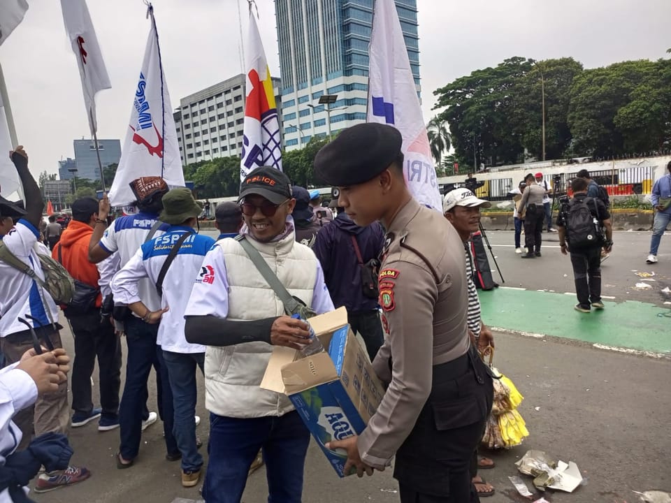 Aksi Simpatik, Polisi Bagikan Air Mineral dan Roti kepada Buruh di Depan DPR/MPR