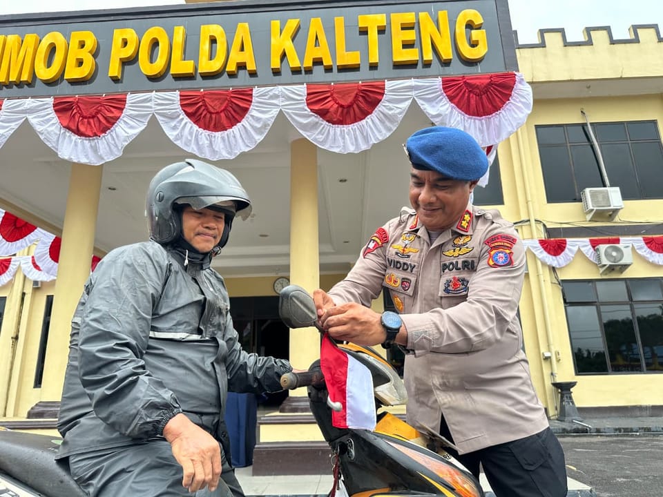 Jelang 17 Agustus, Brimob Kalteng Gelorakan Patriotisme Lewat Pembagian Bendera ke Warga
