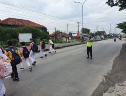 Beri Rasa Aman, Satlantas Polres Demak Bantu Anak Sekolah Menyebrang Jalan