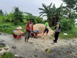 Bhabinkamtibmas Gotong Royong Bantu Warga Membangun Jalan Desa
