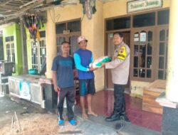 Bhabinkamtibmas Polsek Karangtengah Bantu Distribusikan Bansos Untuk korban Banjir di Desa Binaanya
