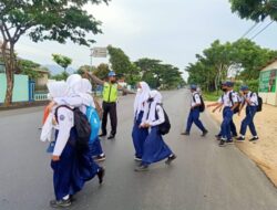 Kanit Lantas Polsek Kragan Bantu Anak Sekolah Menyeberang Jalan