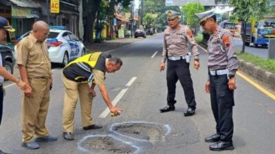 Kerusakan Jalan Pantura Batang: Petugas Berikan Tanda dengan menggunakan cat pilox warna putih