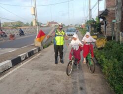 Polisi Bantu Lancarkan Lalin dan Anak Sekolah Menyebrang Jalan