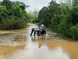 Bhabinkamtibmas Polsek Dedai beserta Piket SPKT Polsek Dedai bantu dorong Sepeda Motor Warga yang Mogok menerobos Banjir