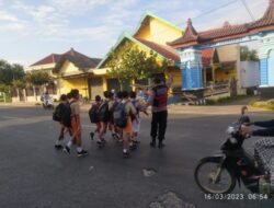 Polisi Sabahat Anak, Anggota Polsek Kragan Menyeberangkan Pelajar Sekolah