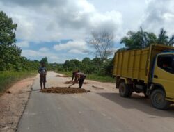 Personel Sat Binmas Polres Lamandau Bantu Warga Timbun Jalan Rusak