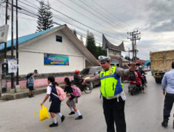 Personel Polres Humbahas Bantu Anak-Anak Sekolah Menyebrang Jalan