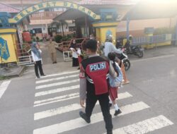 Personel Satsamapta Polres Lamandau Bantu Anak Sekolah Menyeberang Jalan