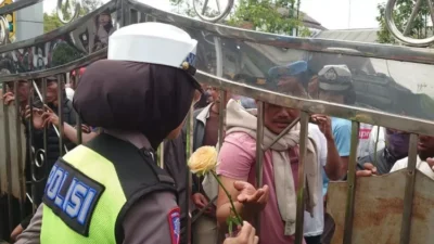 Polwan Bagikan Bunga Mawar dan Air Mineral Kepada Demonstran Tolak Pilkades Ditunda di Banjarnegara